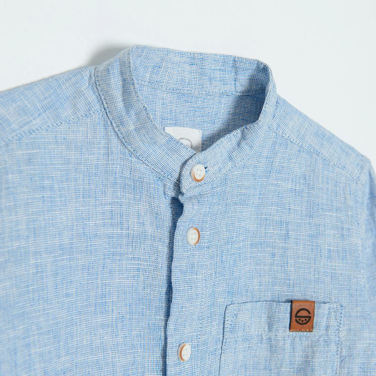 Light blue denim long sleeve button down shirt that rolls up to a button