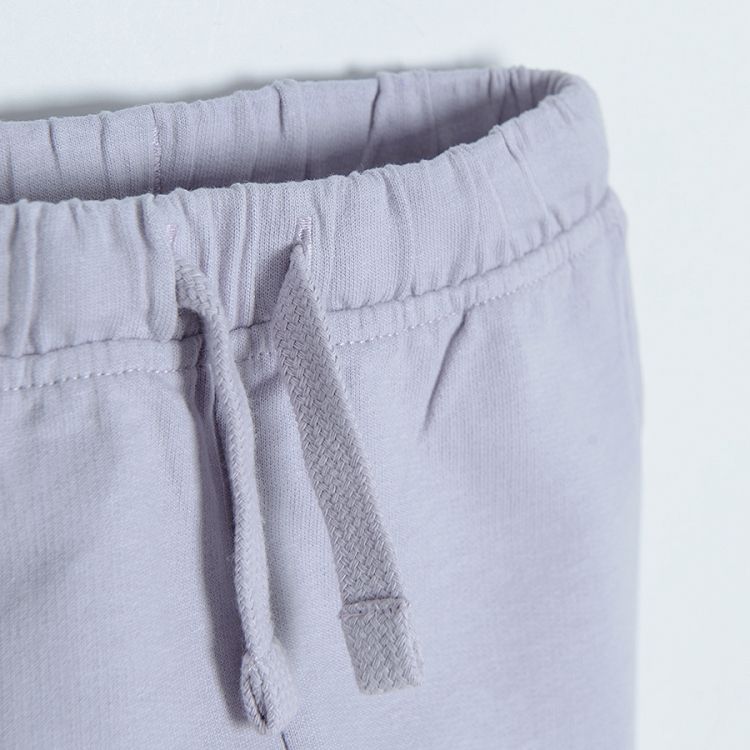 Light violet jogging pants with adjustable waist and elastic band around the ankes