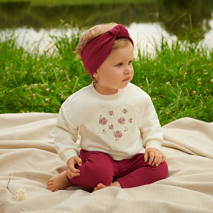 White sweatshirt with a heart print and burgundy leggings and headband