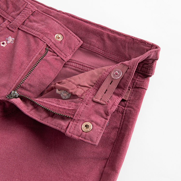 Burgundy trousers with flowers embroidered around the pockets