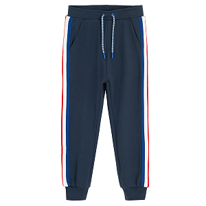 Blue jogging pants with white and red stripes on the side