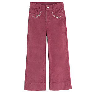 Burgundy trousers with flowers embroidered around the pockets