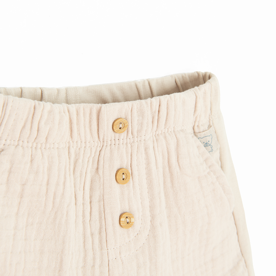 Beige shorts with buttons in the middle