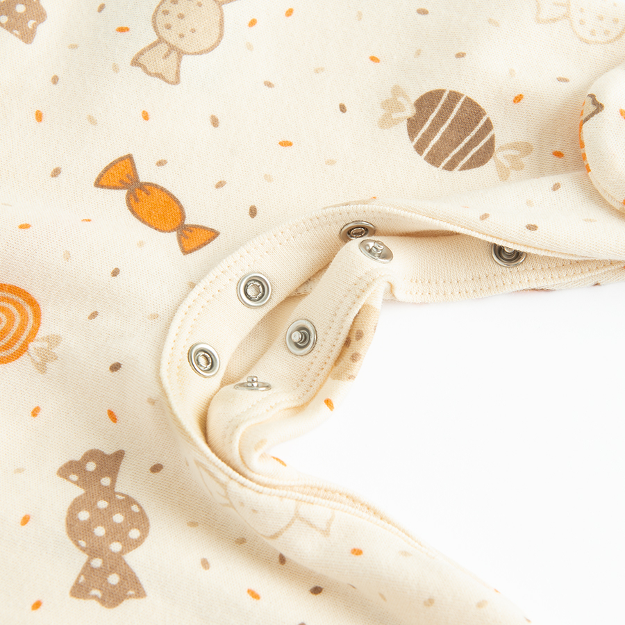 Ecru long sleeve footed overall with candies print and side buttons print