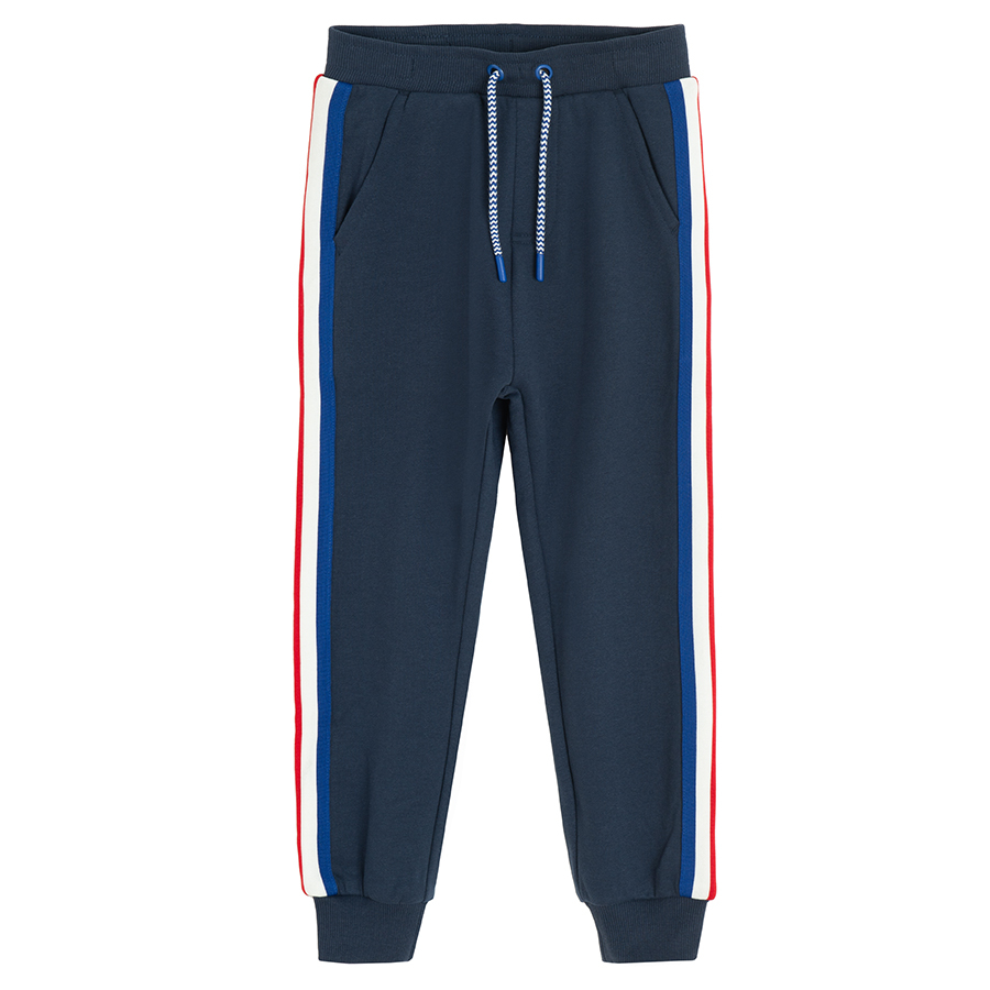 Blue jogging pants with white and red stripes on the side