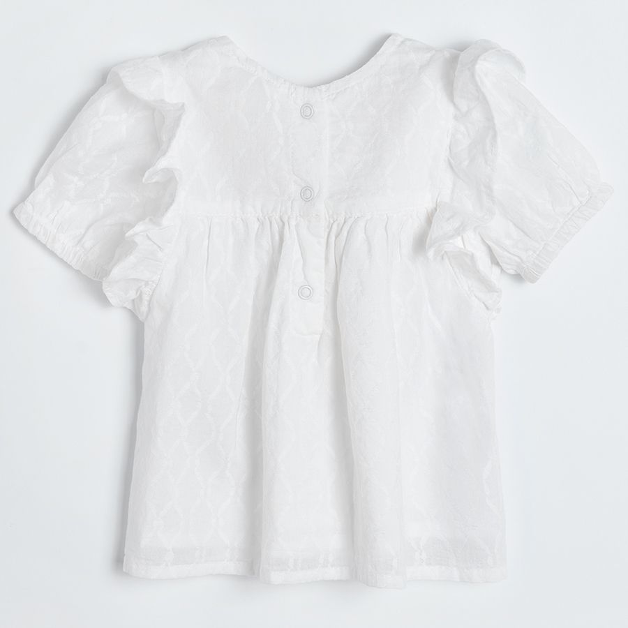 Cream short sleeve blouse with embroidery on the top and ruffle on shoulders