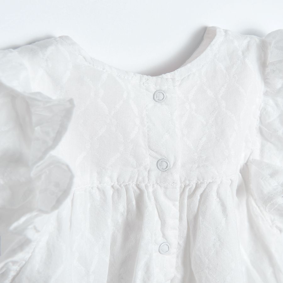 Cream short sleeve blouse with embroidery on the top and ruffle on shoulders